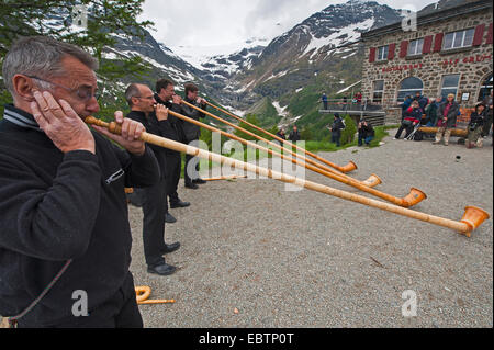 Alphorn-Gebläse vor einer Kulisse von Apls, Schweiz Stockfoto