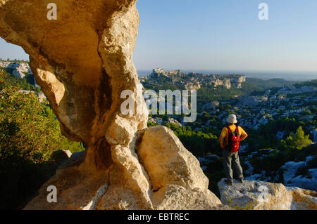 Wanderer stehen neben einem Felsbogen und genießen die Aussicht, Frankreich, Provence, Baux-En-Provence Stockfoto