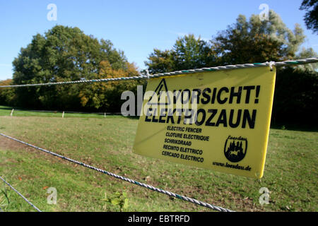 Warnschild am elektrischen Zaun einer Weide, Deutschland, Nordrhein-Westfalen, Düsseldorf Stockfoto