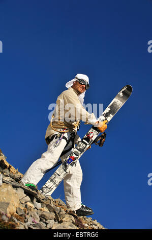 Freeride-Skifahrer getarnt als altmodisch Abenteurer auf felsigen Hang stehend Stockfoto
