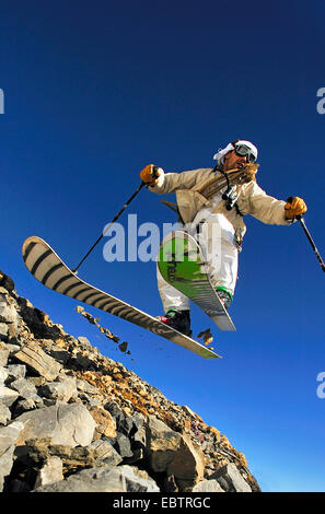 Freeride-Skifahrer getarnt als altmodisch Abenteurer auf felsigen Hang bergab Stockfoto