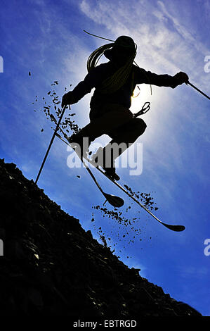 Freeride-Skifahrer getarnt als altmodisch Abenteurer auf felsigen Hang bergab Stockfoto