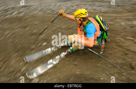 Freeride-Skifahrer auf felsigen Hang bergab Stockfoto