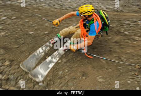 Freeride-Skifahrer auf felsigen Hang bergab Stockfoto