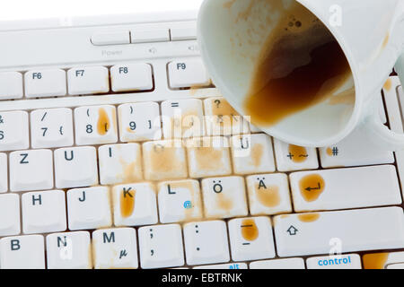 Tasse Kaffee verschüttet auf einer Computertastatur Stockfoto