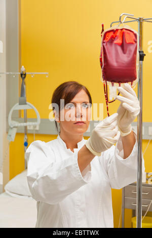 Krankenschwester im Krankenhaus mit Blutkonserven. Infusion von Spenderblut Stockfoto