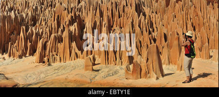 weibliche Touristen fotografieren im roten Kalkstein Karstgebilde, Madagaskar, Nationalpark Tsingy de Bemaraha Tsingy Stockfoto