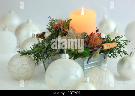 Weihnachten Blumenarrangement mit Kerze und Weihnachtskugeln Stockfoto