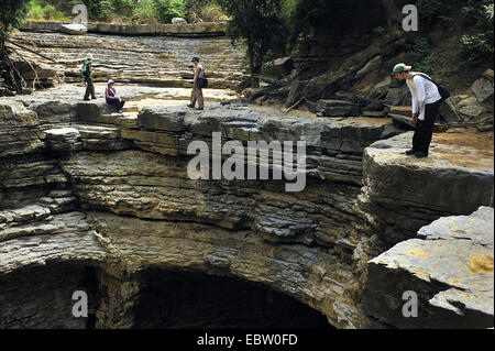 Touristen im trockenen Flussbett in der Nähe von riesigen Waschbecken Loch, Madagaskar, Ankarana Nationalpark Stockfoto