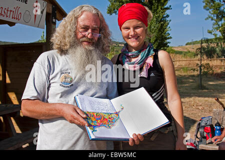 Junge Pilger auf dem Jakobsweg zwischen Logroño±o und Ventosa stand neben einem anstaltswaerter Zeigt ein Gästebuch mit einer Zeichnung von ihr, Spanien, Baskenland, La Rioja, Logroño±o Stockfoto