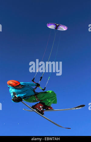 Man schwebt vor blauem Himmel Paragliding mit Skiern, Frankreich Stockfoto