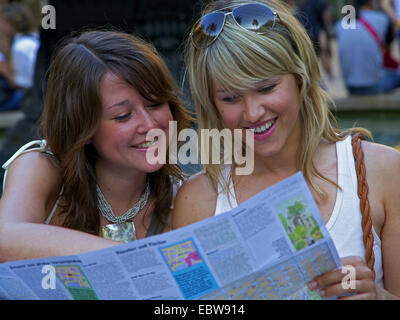 zwei junge Frauen, die einen Reiseführer lesen Stockfoto