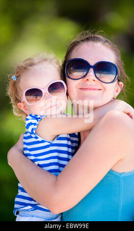 Mutter und Tochter mit Sonnenbrille umarmt Stockfoto