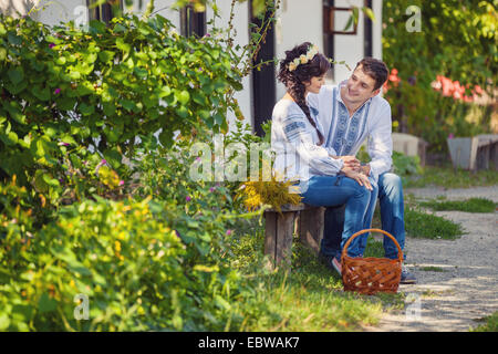 Schönes paar auf Bank sitzend und flirten Stockfoto