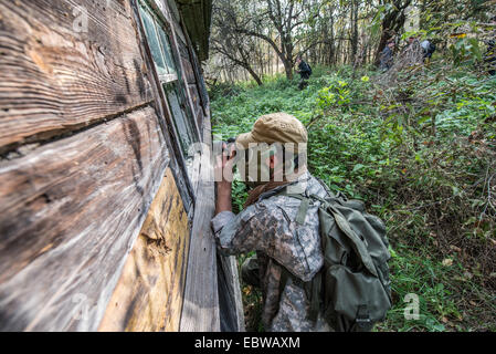 Tourist in Gasmaske nehmen Foto von alten Holzhaus in Wüstung Stechanka, Sperrzone von Tschernobyl, Ukraine Stockfoto