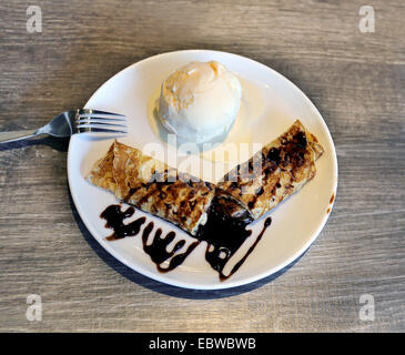 Foto von leckeren Pfannkuchen und Eis auf einem weißen Teller Stockfoto