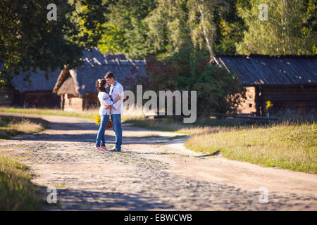 Junges Paar in der ukrainischen Stil Kleidung küssen, während er auf der Straße im alten Dorf Stockfoto