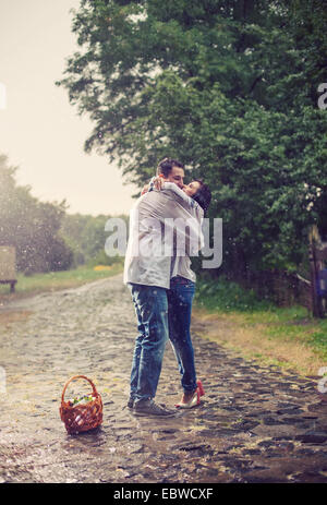 Junges Paar in der ukrainischen Stil Kleidung küssen stehen unter Regen Stockfoto