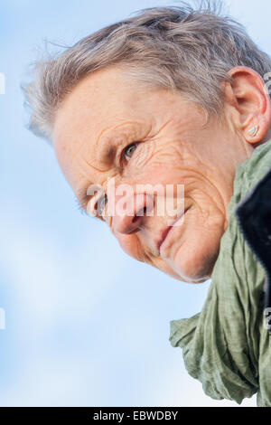 Beautiful senior Woman tummeln sich auf den Strand schreitende zusammen mit ausgebreiteten Armen und einem Lächeln der Wertschätzung, wie sie Natur genießt eine Stockfoto