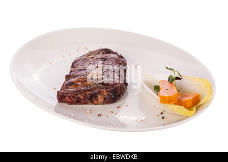 Lecker gegrilltes Rindersteak mit einem gezwirbelten Stück Butter und ein Zweig frischer Rosmarin garniert und serviert auf einem weißen Teller, enge u Stockfoto