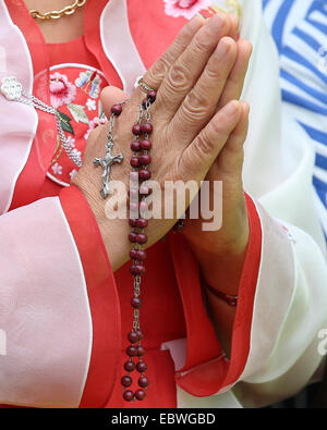 Eine südkoreanische katholischen hält ihren Rosenkranz während der Messe für Frieden und Versöhnung in Myeongdong Catholic Cathedral 18. August 2014 in Seoul, Südkorea. Der Papst ist in Südkorea auf der erste Papstbesuch in asiatischen Nation in einem Vierteljahrhundert. Stockfoto