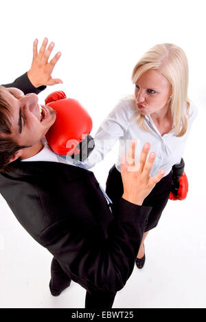 Geschäftsfrau mit Boxhandschuhen Pflanzen einen Schlag auf ein Geschäftsmann Kinn Stockfoto