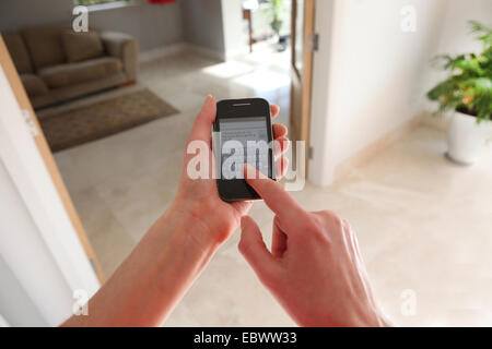 Mädchen mit Smartphone zu Hause Stockfoto