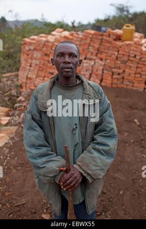 Porträt des Arbeitnehmers vor Lehmziegeln, Burundi, Karuzi, Karuzi Stockfoto