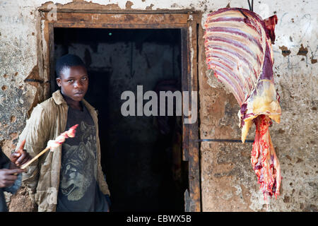 Metzger bei der Arbeit, Rippen einer Kuh hängen nächsten Eingang, Burundi, Bujumbura Rural, Bugarama Stockfoto