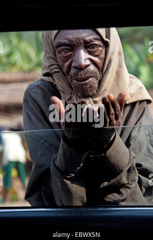 älterer Mann betteln am offenen Fenster eines Autos, Burundi, Bujumbura Rural, Bugarama Stockfoto