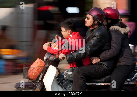 Familie Reiten durch die Stadt auf einem Motorroller, Vietnam, Hanoi Stockfoto