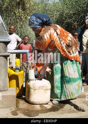 um Wasser zu bekommen, bei einer Quelle in einem Dorf in Uganda, Uganda Stockfoto