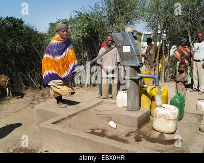 um Wasser zu bekommen, bei einer Quelle in einem Dorf in Uganda, Uganda Stockfoto