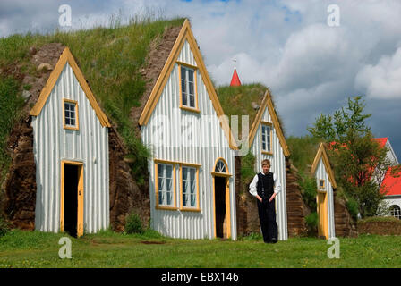 Junge in Tracht Torf Häuser mit Rasen Dächer in Freilichtmuseen Glaumbaer, Island Stockfoto