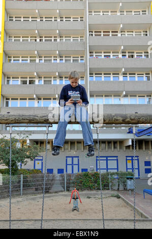 Jungen spielen mit Gameboy vor Hochhaus, Deutschland, Chorweiler, Köln Stockfoto