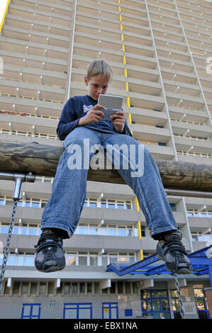 Jungen spielen mit Gameboy vor Hochhaus, Deutschland, Chorweiler, Köln Stockfoto