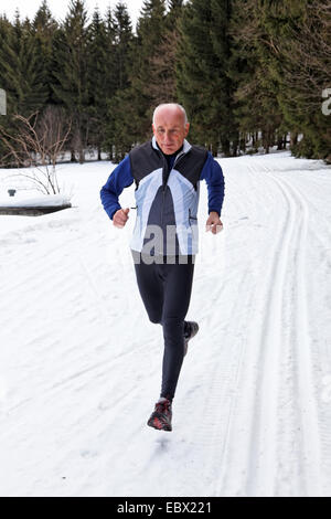 Senior, Joggen im Schnee Stockfoto