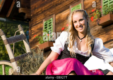 Frau im Dirndl auf Bauernhof, Österreich Stockfoto