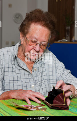 alte Frau zählt ihr Geld Stockfoto