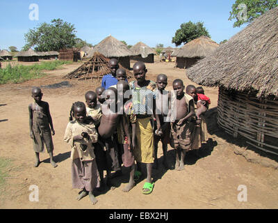 Gruppenfoto der Einwohner von einem Flüchtlingslager für intern Vertriebene in Nord-Uganda um Gulu, Häuser einfach Schlamm im Hintergrund, Uganda, Gulu Stockfoto