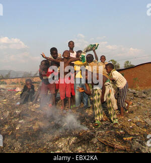 Kinder posiert auf einer Deponie in den Slums hinter brennenden Müll, Burundi, Bujumbura Mairie, Buyenzi, Bujumbura Stockfoto