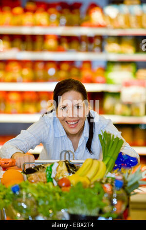 junge Frau im Supermarkt kauft Lebensmittel und Früchte Stockfoto