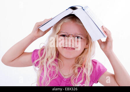 Mädchen mit Buch auf dem Kopf Stockfoto