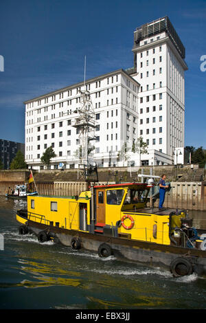 Mann auf einem Schiff in den Innenhafen, Kontorhaus im Hintergrund, Duisburg, Ruhrgebiet, Nordrhein-Westfalen, Deutschland Stockfoto
