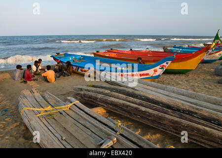 Fischer sitzen am Sandstrand neben ihren Booten, Chennai, Tamil Nadu, Indien und Marina Beach Stockfoto