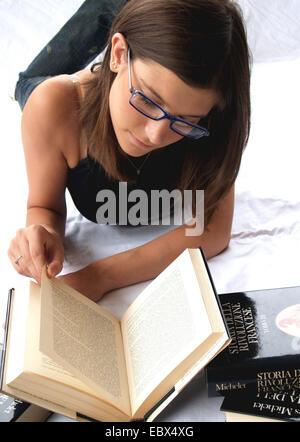 Studentin, die auf dem Boden ein Buch zu lesen Stockfoto