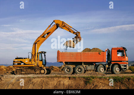 Bagger beladen LKW auf einer Baustelle Stockfoto