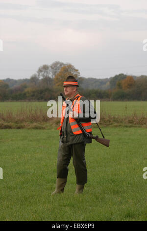 Jäger stehen und warten auf einer Wiese während einer Treibjagd im Oktober, Deutschland Stockfoto