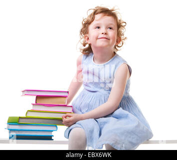 Kleines Mädchen mit Büchern sitzen auf einer Bank Stockfoto