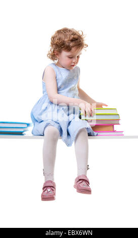 Kleines Mädchen mit Büchern sitzen auf einer Bank Stockfoto